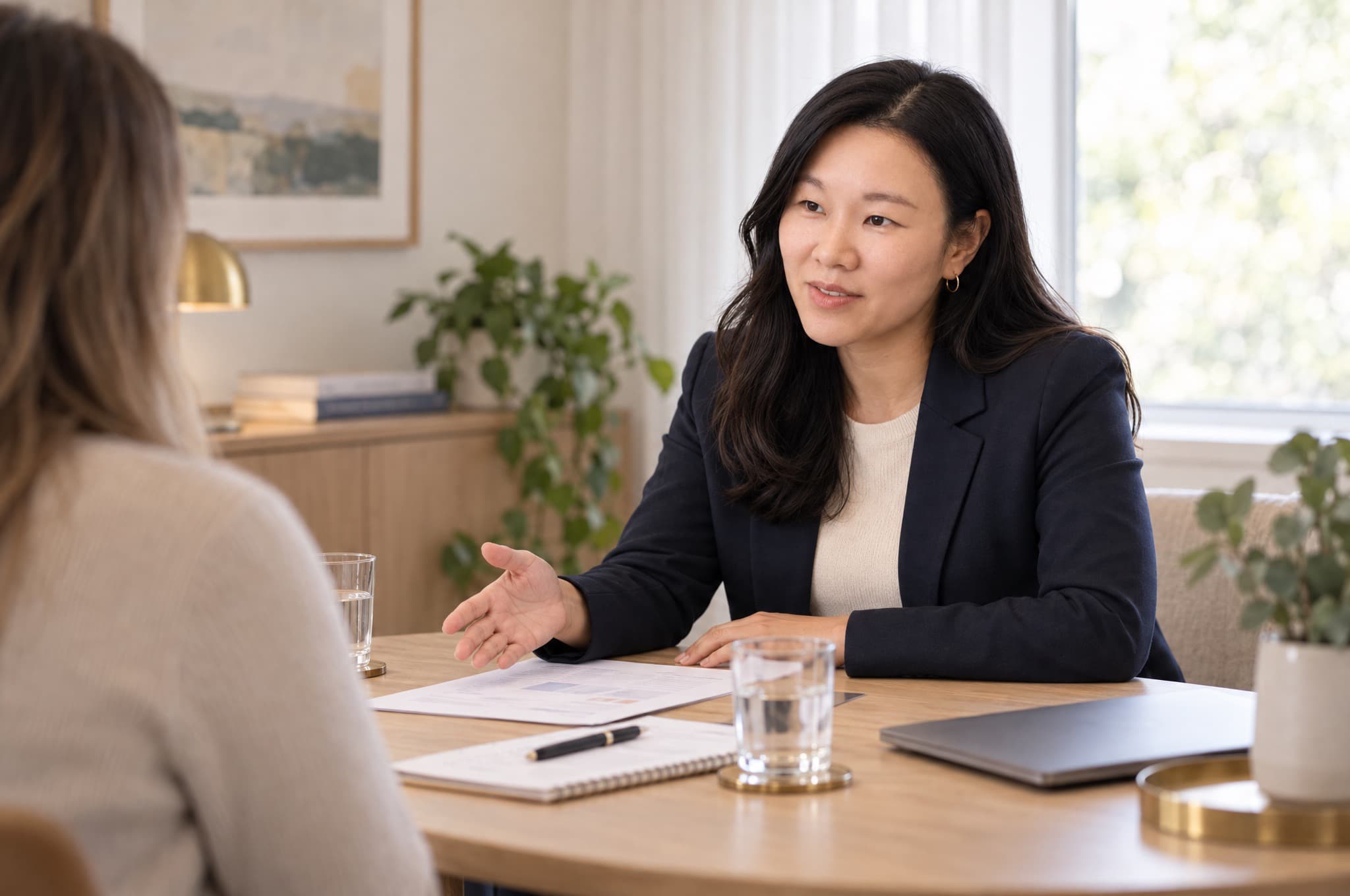 Christine in conversation with a client across a table, seen over the client's shoulder